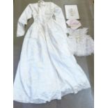 An early 20th Century dress and bonnet with photograph of a girl wearing the same dress and