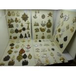 A large collection of mainly military regimental cap badges, also a silver ARP badge, a 1915 On