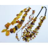 A silver and amber necklace and two other amber necklaces