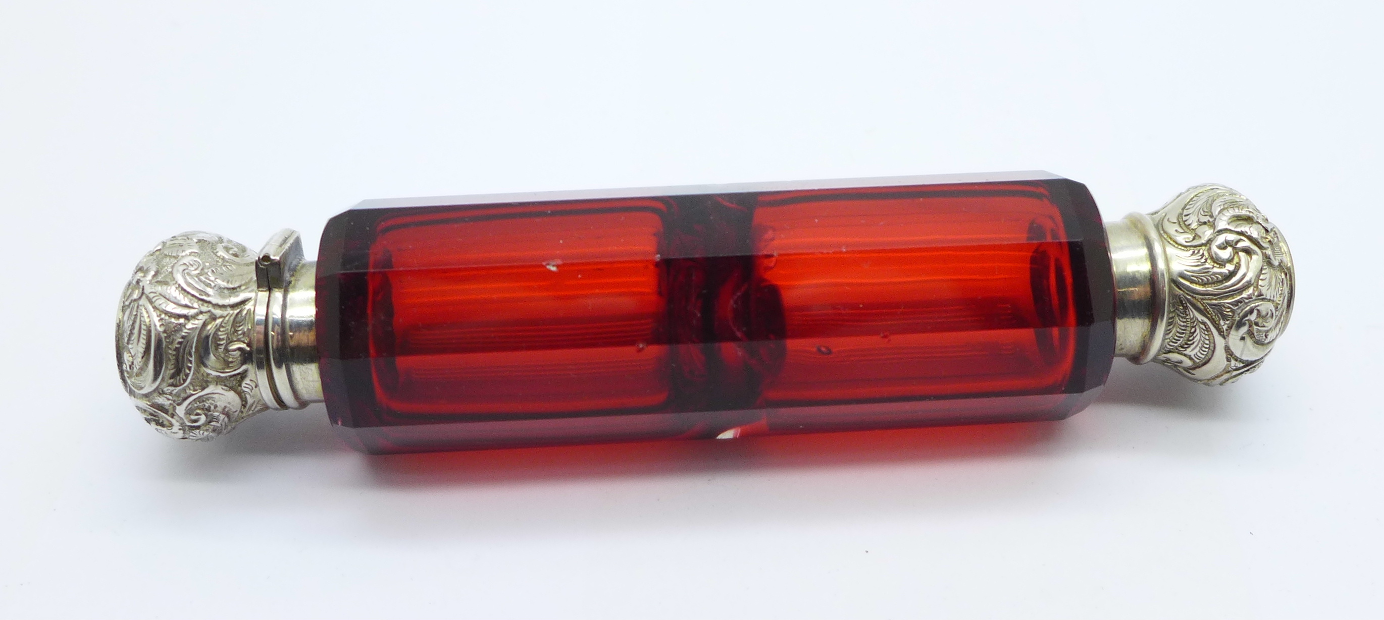 A silver mounted double ended ruby glass scent bottle, tests as silver