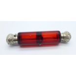 A silver mounted double ended ruby glass scent bottle, tests as silver