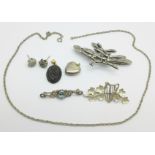 Three silver brooches, a silver locket, a silver mounted pendant, etc.