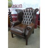 A mahogany and brown leather wingback armchair