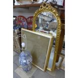 A large blue and white table lamp, a gilt framed mirror and a frame