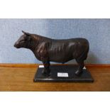 A bronze figure of a bull, on black marble plinth, 17cms h