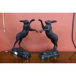 A pair of bronze boxing hares, on black marble socles, 29cms h