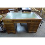 A yew wood and green leather topped pedestal desk