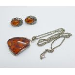 A large amber pendant and chain and a pair of silver and amber earrings