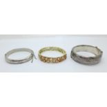 Two silver bangles and one other bangle