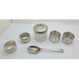 Four silver napkin rings, a silver spoon and a silver topped glass hair tidy, 139g