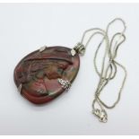 A large silver mounted carved gemstone pendant with lady's profile on silver chain