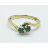 A 9ct gold, two stone emerald ring, 1.9g, K