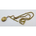 A yellow metal Albert chain with plated locket, one metal clip and metal T-bar, yellow metal chain