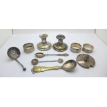 Two silver napkin rings, a silver sifter spoon, two other spoons, a silver preserve lid, a pair of