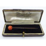 A 9ct gold and carved coral stick pin with box