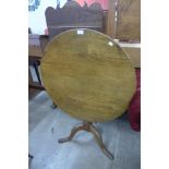 A George III oak circular tilt top tripod tea table