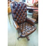A mahogany and buttoned chestnut brown revolving desk chair