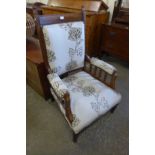 An Arts and Crafts oak and fabric upholstered armchair