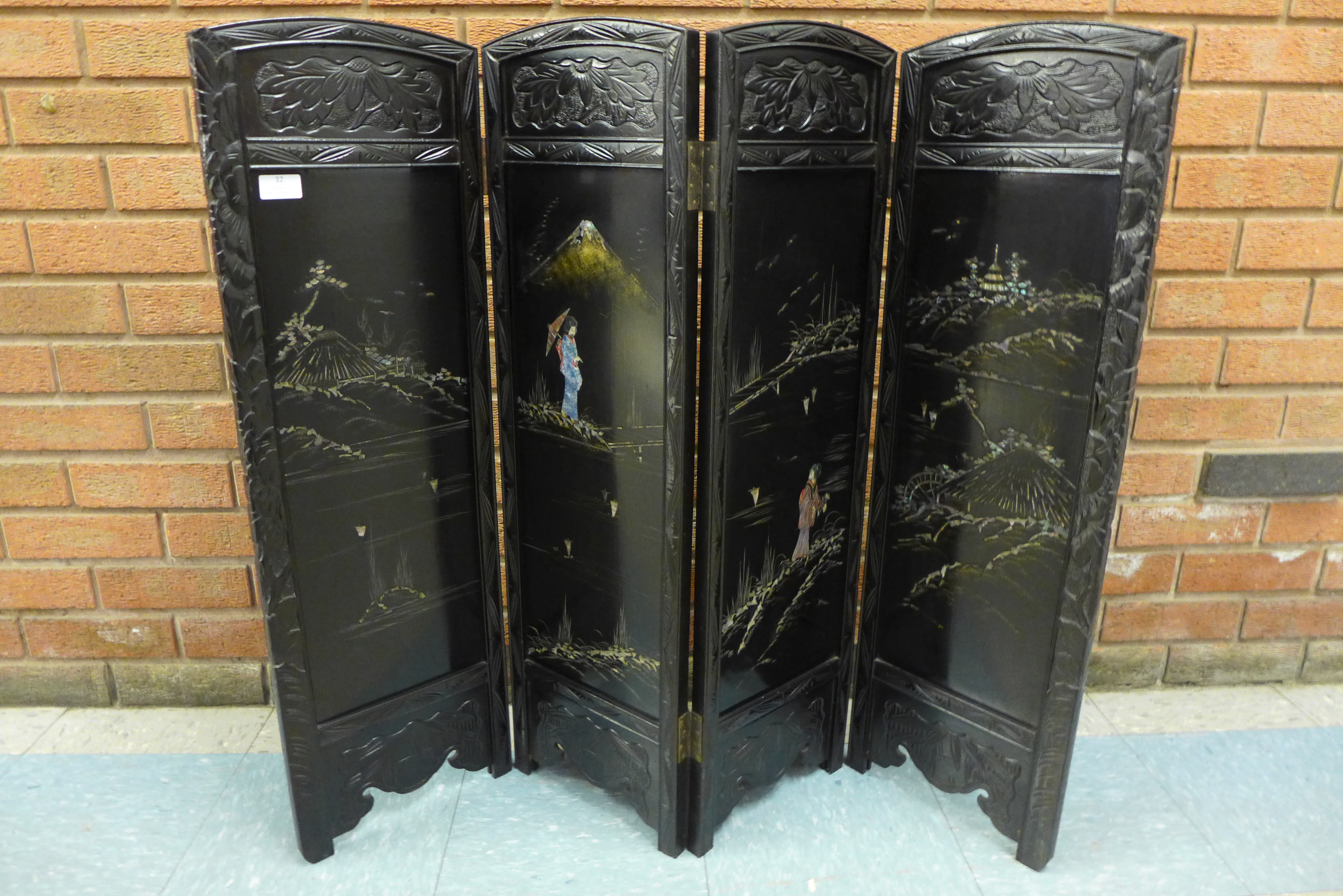 An early 20th Century Japanese carved ebonised and mother of pearl inlaid folding table screen