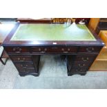 A mahogany and green leather topped pedestal desk