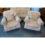 A beige floral upholstered three piece lounge suite