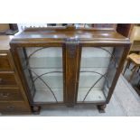 A carved oak two door display cabinet