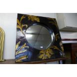 A black and gilt floral design framed mirror