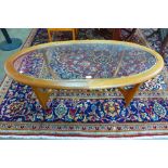 A Stonehill Stateroom teak and glass topped oval coffee table