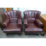 A pair of burgundy leather wingback armchairs