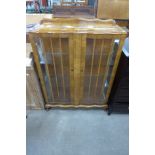 A walnut serpentine two door display cabinet