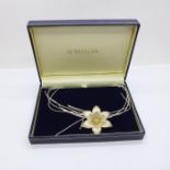 A silver flower necklace, boxed