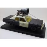 A heavy die-cast model Blues Brothers police car on a plinth, 31cm