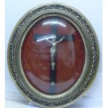 An antique oval convex glass frame with crucifix, width of frame 49cm