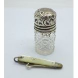 A silver topped bottle and a silver and mother of pearl button hook