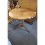 An oak circular tripod table