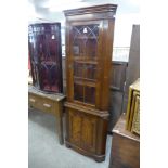 A mahogany freestanding splay front corner cabinet