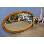 An oval pine framed mirror and another