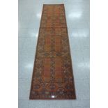 A terracotta ground runner rug, 263 x 68cms