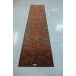 A red ground runner rug, 352 x 86cms