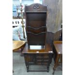 A small carved oak cabinet and a newspaper stand