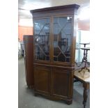 A George III oak freestanding splay front corner cabinet