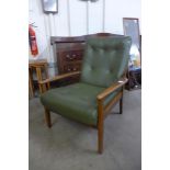 A teak and green vinyl armchair