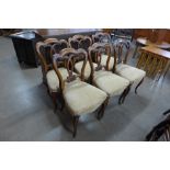 A set of six Victorian walnut balloon back dining chairs