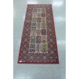 A small red ground runner rug, 181 x 80cms
