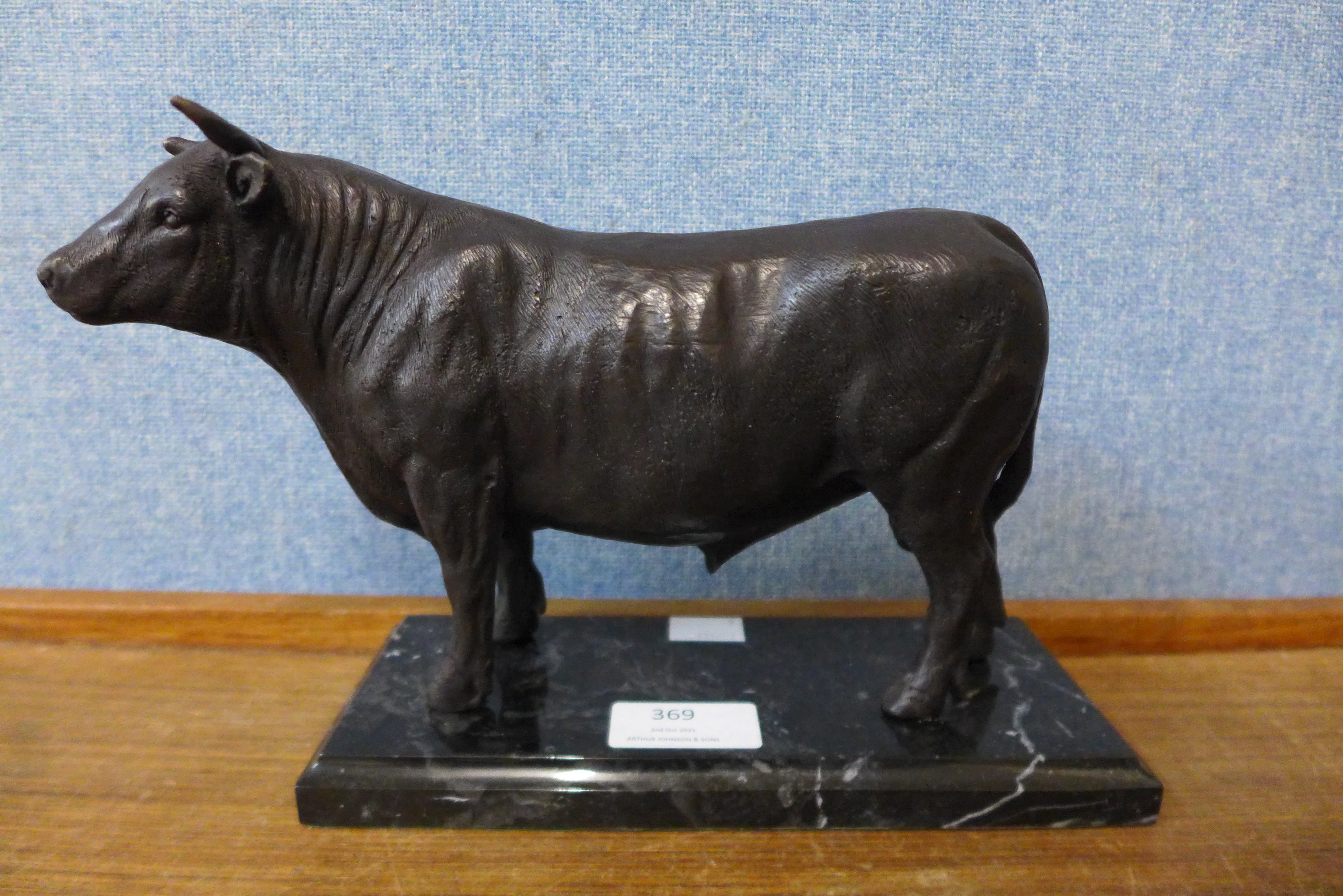 A bronze figure of a bull, on black marble socle, 16cms h