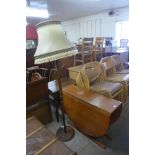 A teak drop-leaf dining table and a standard lamp