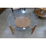 A teak and glass topped circular coffee table