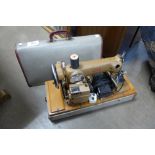 A vintage Alpha cased sewing machine and a child's cot