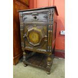 A Jacobean Revival carved oak and walnut geometric side cabinet