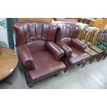 A pair of burgundy leather wingback armchairs